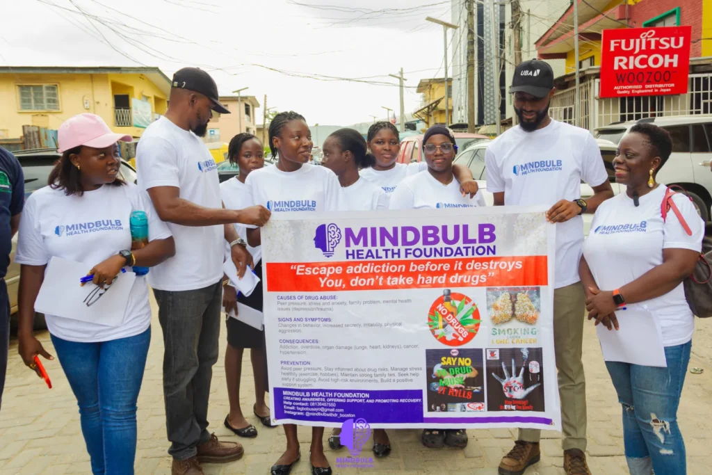Mindbulb Health Foundation volunteers holding the “Escape addiction before it destroys you” anti-drug banner on the street